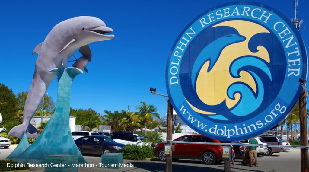 Dolphin Research Center Sign in Marathon Florida with dolphins in lagoon. FloridaKeysVillas.com
