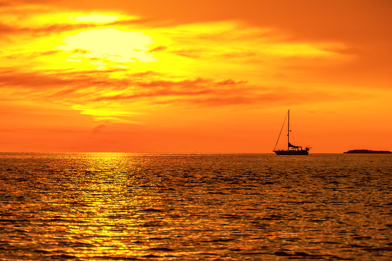 Beautiful Bright Yellows, Orange and Reds Sky at Sunset with shimmering ocean water in the Florida Keys. FloridaKeysVillas.com