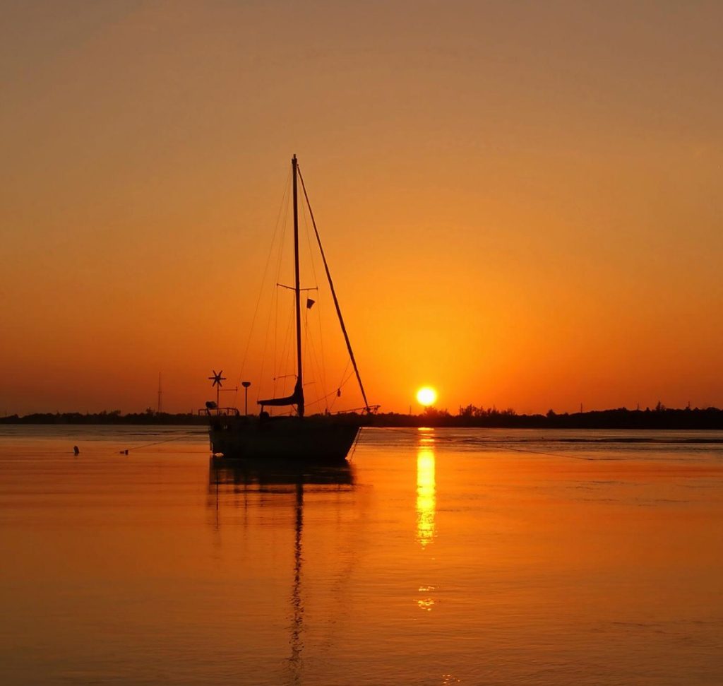 Colorful Florida Keys sunset seen from waterfront rentals with docks in Marathon Florida. Spectacular Florida Keys Sunsets in the Fall. Florida Keys sunset with boats. Sailboat and a sunset in Marathon Florida. FloridaKeysVillas.com